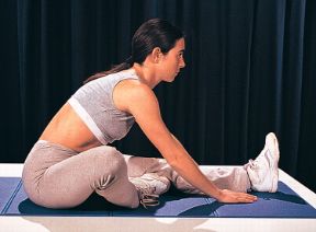 Esercizio per il busto. Movimenti per il busto dalla posizione seduta. Flessioni del tronco con la pianta del piede che aderisce alla parte interna della coscia.