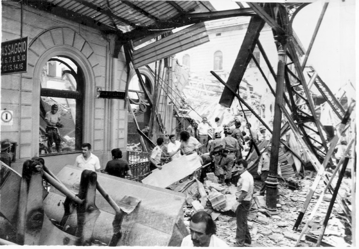 Le macerie della pensilina del 1° binario L'ordigno distrusse anche trenta metri della pensilina e investì il treno Ancona-Chiasso che si trovava sul primo binario. Venne distrutto anche il parcheggio dei taxi antistante la stazione. 