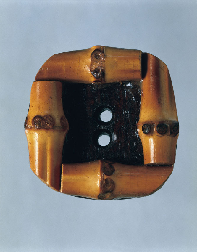 Bottone in legno e metallo prodotto per Chanel Coco Chanel, con i suoi modelli anticonformisti, riuscì a dar voce alla riforma sociale che cambiò il ruolo della donna negli anni Cinquanta. La stilista fu anche una delle prime donne a indossare i pantaloni.